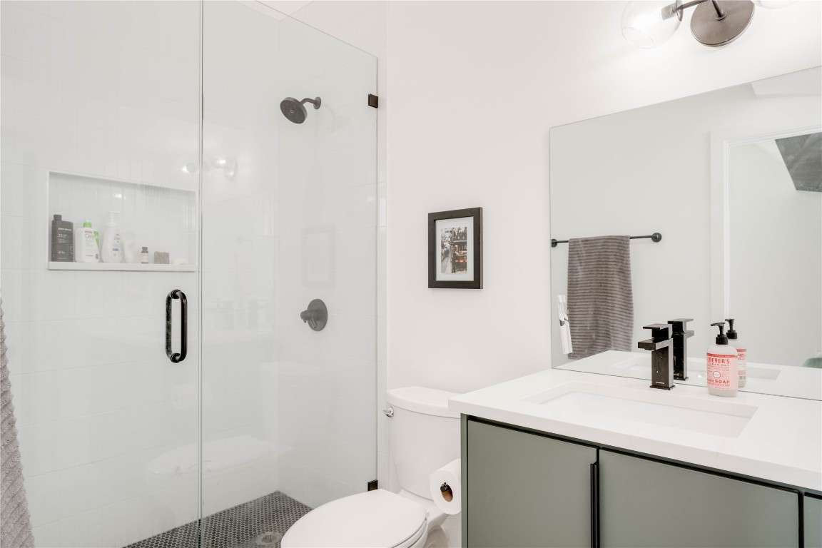 1208 Luna Street, Unit 1 Austin, TX 78721 - Photo 21 of 37 a bathroom with a granite countertop sink a toilet and shower