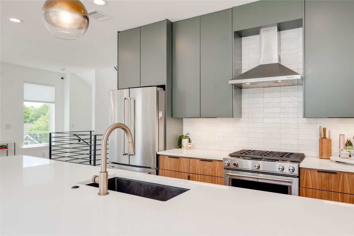 1208 Luna Street, Unit 1 Austin, TX 78721 - Photo 5 of 37 a kitchen with granite countertop a stove a sink and a refrigerator