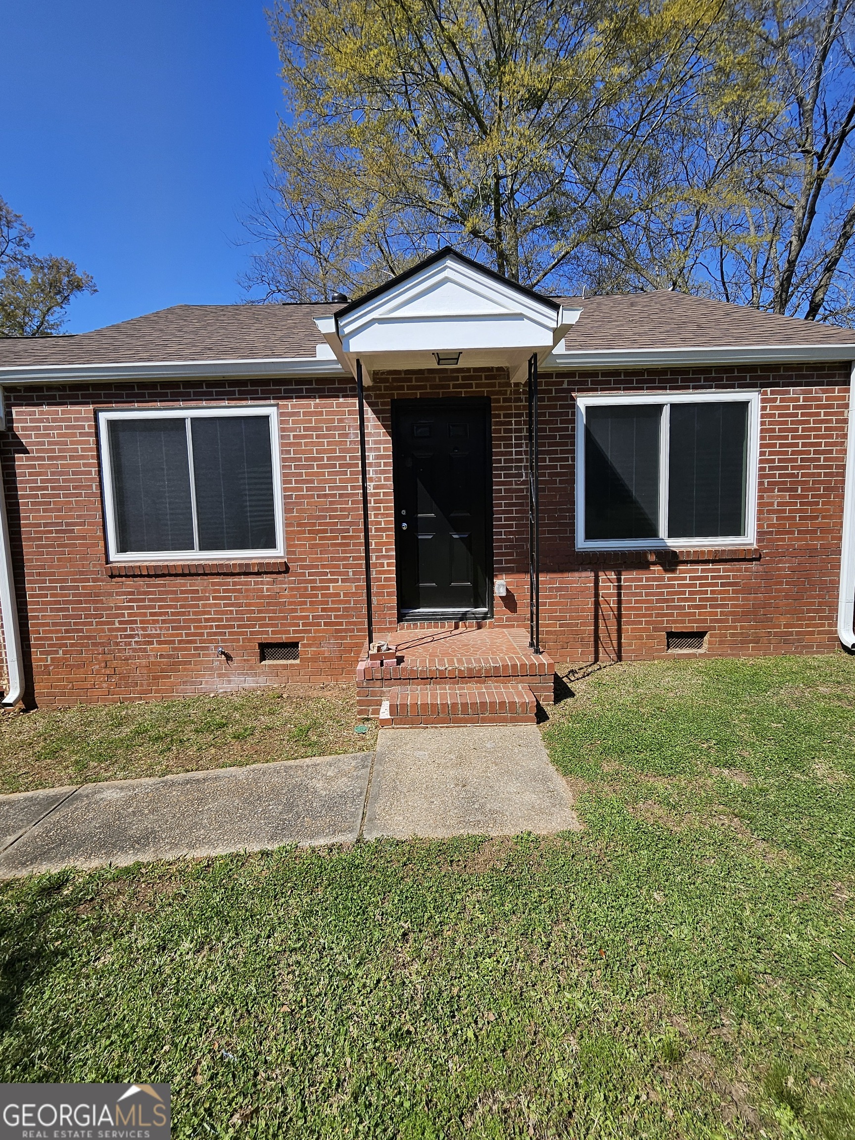 a front view of a house with yard and glass windows