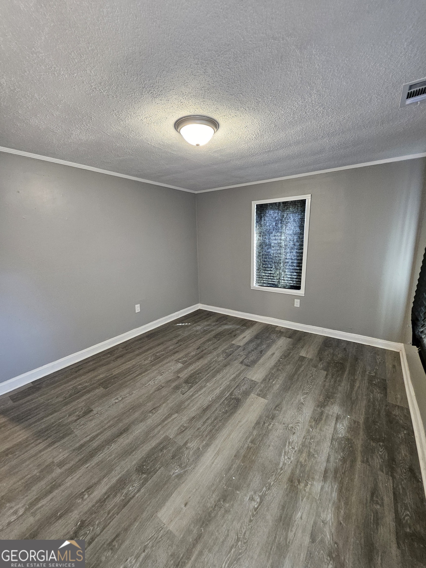 521 Meriwether Street, Unit A Griffin, GA 30224 - Photo 3 of 13 an empty room with wooden floor and window
