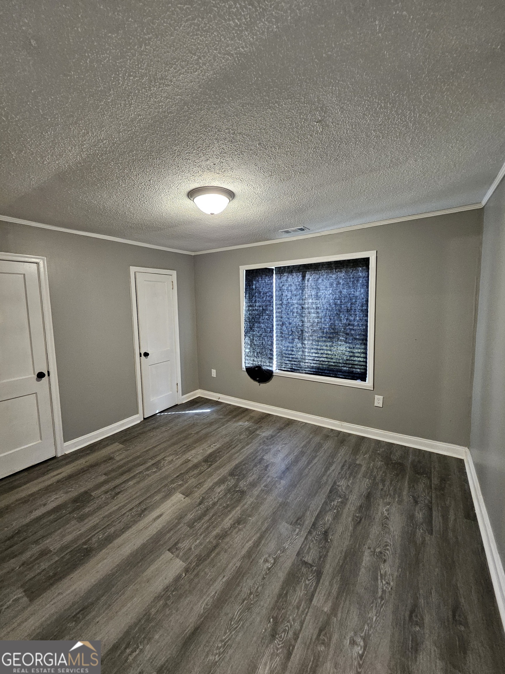 521 Meriwether Street, Unit A Griffin, GA 30224 - Photo 3 of 12 an empty room with wooden floor and windows