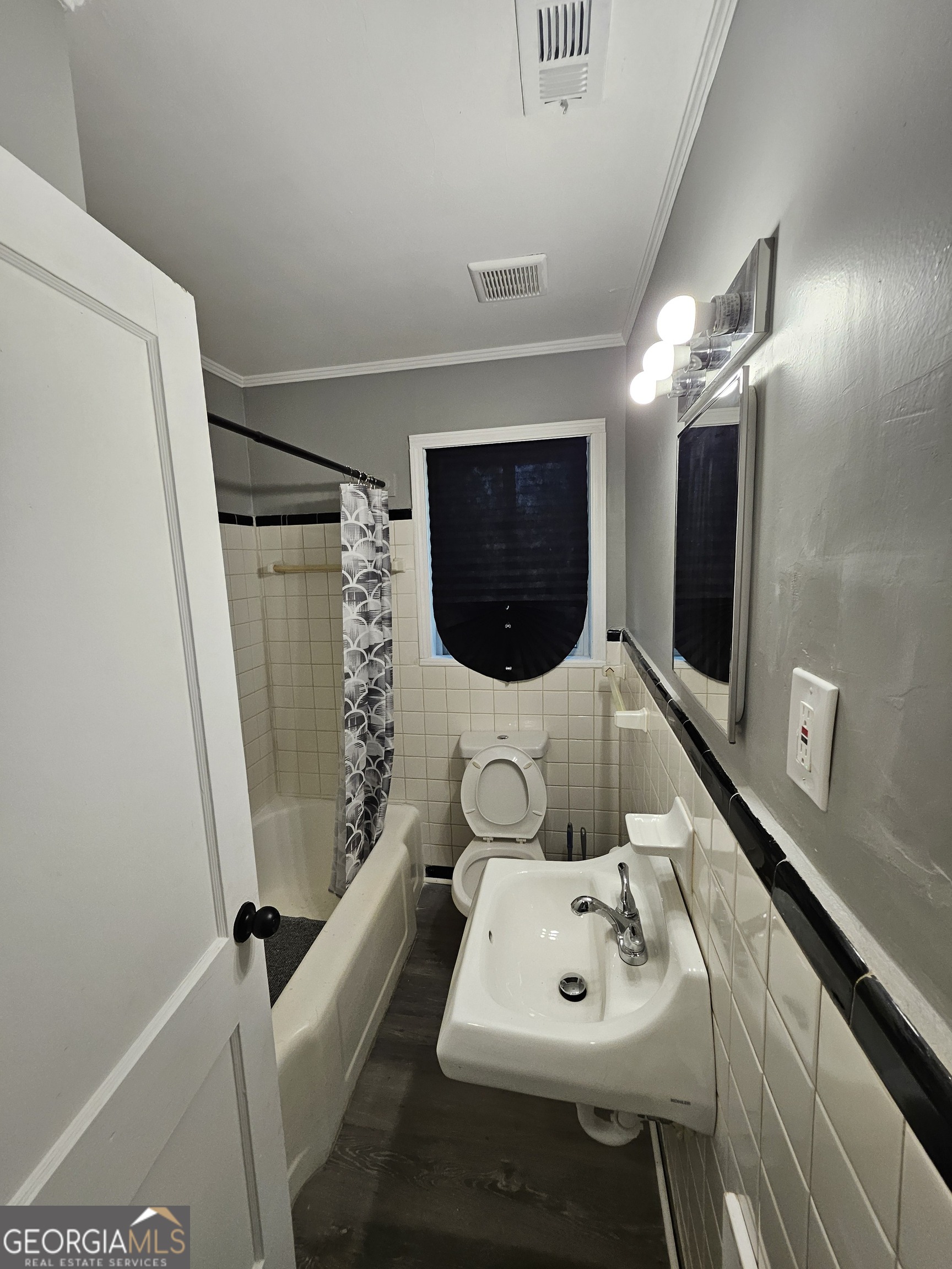 521 Meriwether Street, Unit A Griffin, GA 30224 - Photo 5 of 12 a bathroom with a sink a toilet and mirror