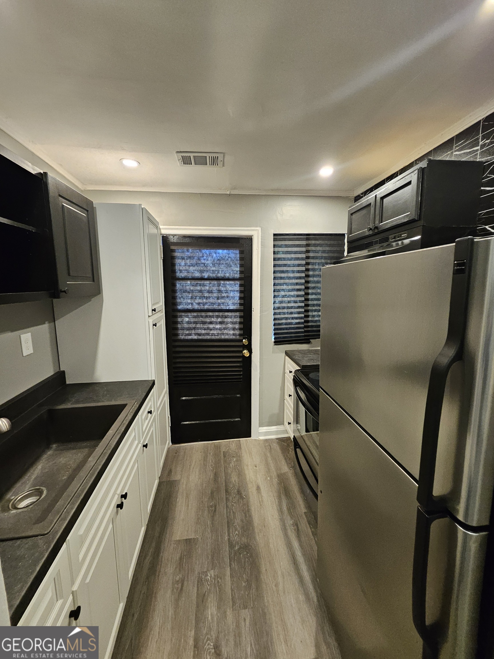 521 Meriwether Street, Unit A Griffin, GA 30224 - Photo 7 of 12 a kitchen with granite countertop a refrigerator and a sink