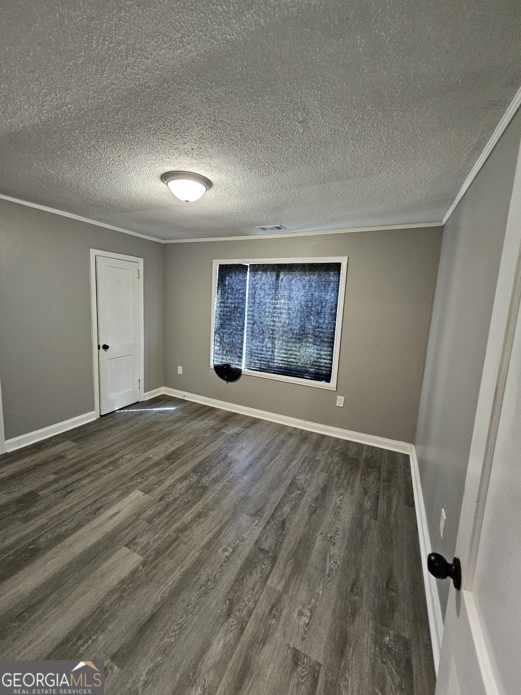 521 Meriwether Street, Unit A Griffin, GA 30224 - Photo 10 of 12 an empty room with wooden floor and windows