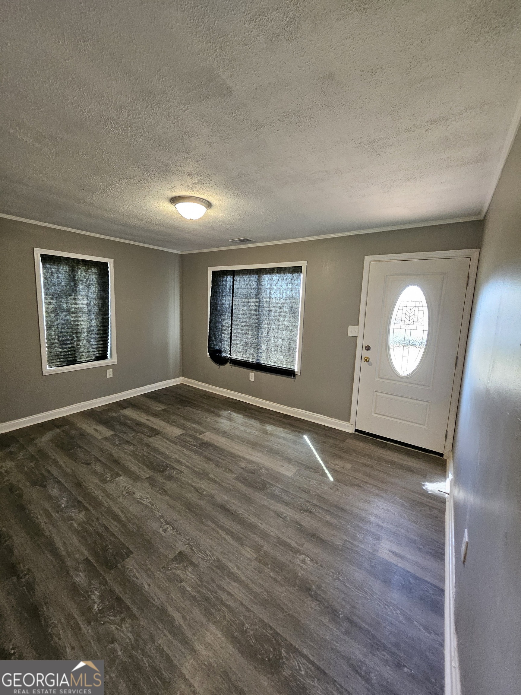 521 Meriwether Street, Unit A Griffin, GA 30224 - Photo 10 of 13 an empty room with wooden floor and window