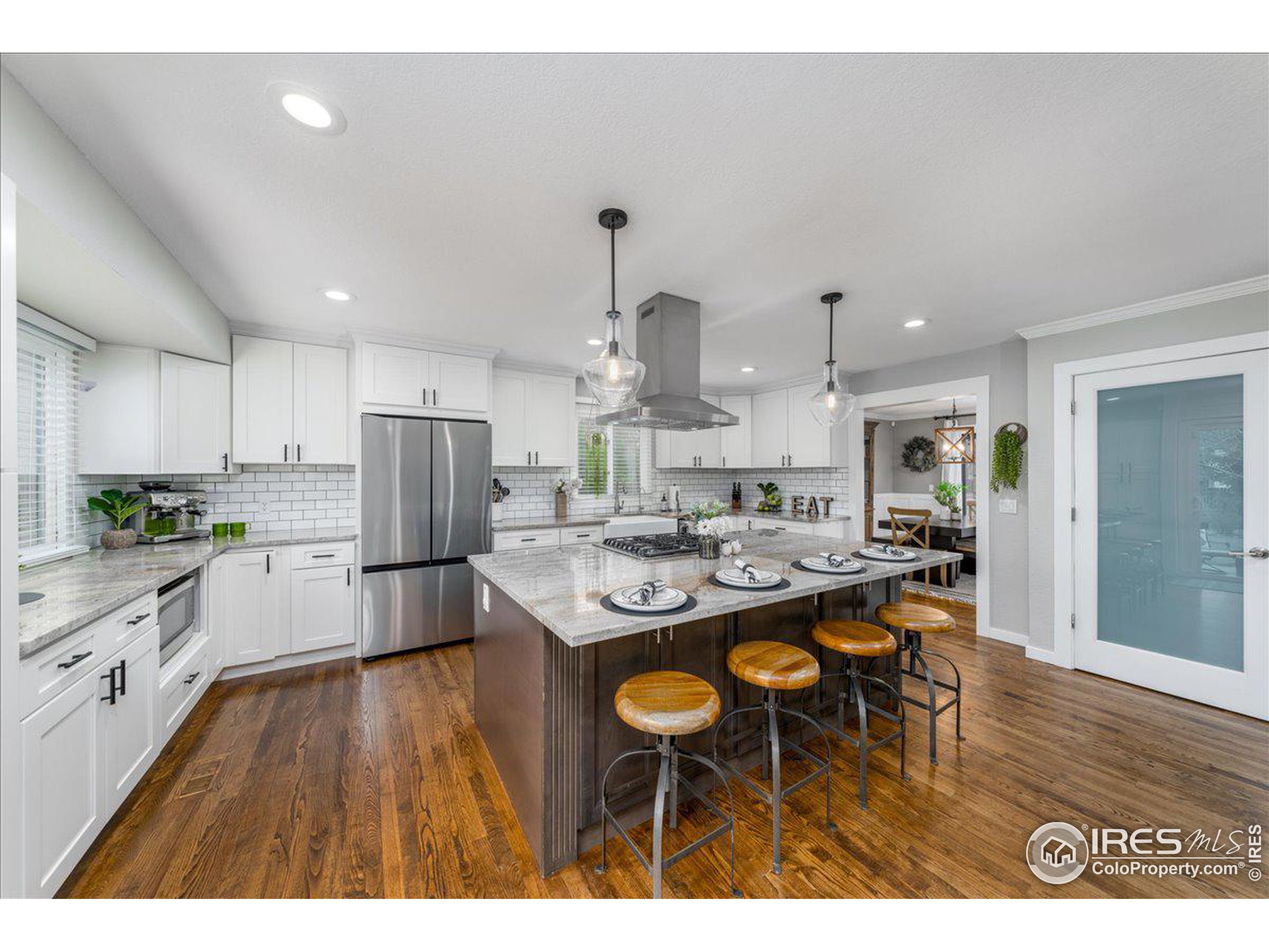 a kitchen with stainless steel appliances kitchen island granite countertop a dining table and chairs