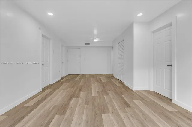 a view of empty room with wooden floor