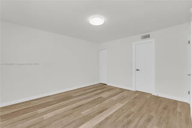 a view of a room with wooden floor and white walls