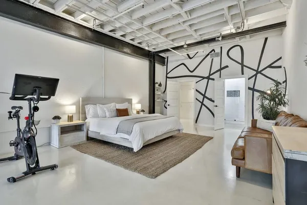 a spacious bedroom with a bed and a flat screen tv