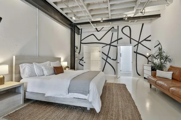 a bedroom with a bed a couch and potted plant