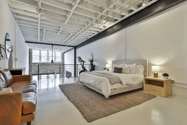 a spacious bedroom with a bed a couch and a chandelier