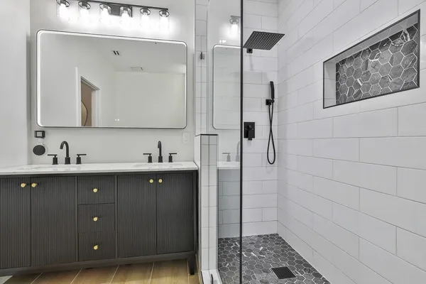 a bathroom with a sink a mirror a vanity and shower