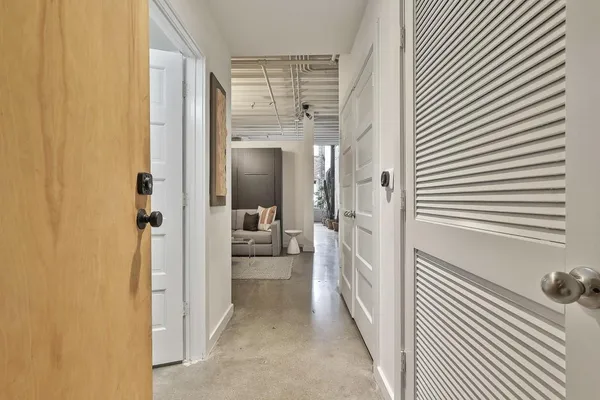 a view of a hallway with a livingroom and a bathroom with a sink