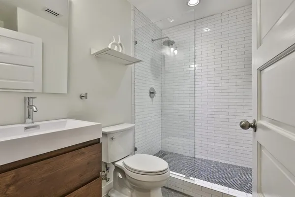 a bathroom with a sink a toilet and shower