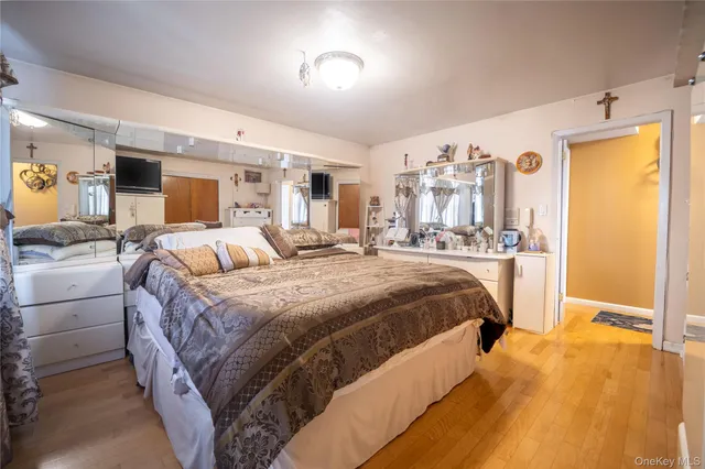 a bedroom with a bed and a large mirror on the dresser