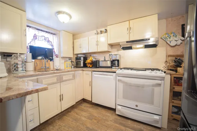 a kitchen with cabinets appliances a sink and a counter space