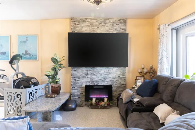 a living room with furniture a fireplace and a flat screen tv