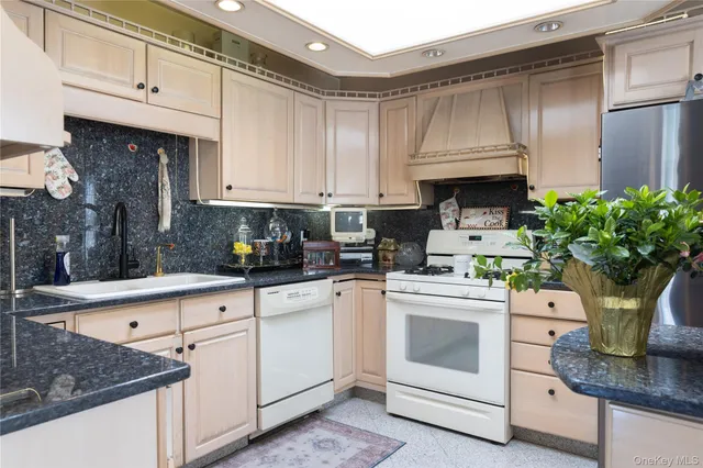 a kitchen with stainless steel appliances granite countertop a sink a stove and cabinets