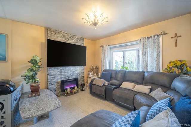 a living room with furniture a flat screen tv and a fireplace