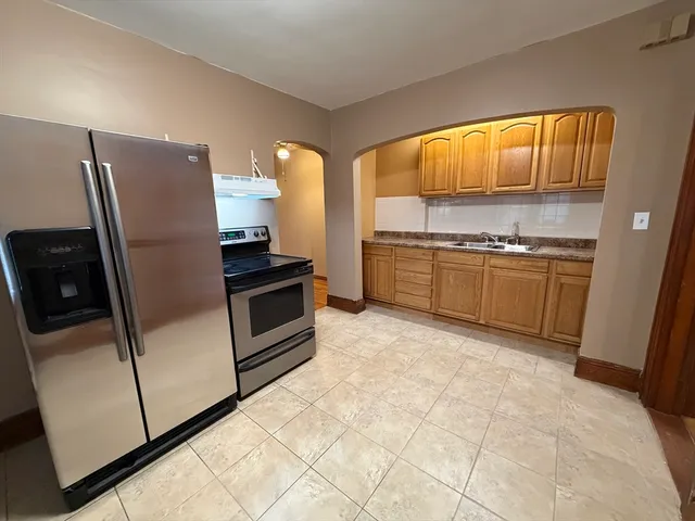 a kitchen with stainless steel appliances granite countertop a refrigerator sink and stove