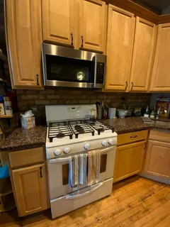 a kitchen with stainless steel appliances granite countertop a stove a microwave and oven