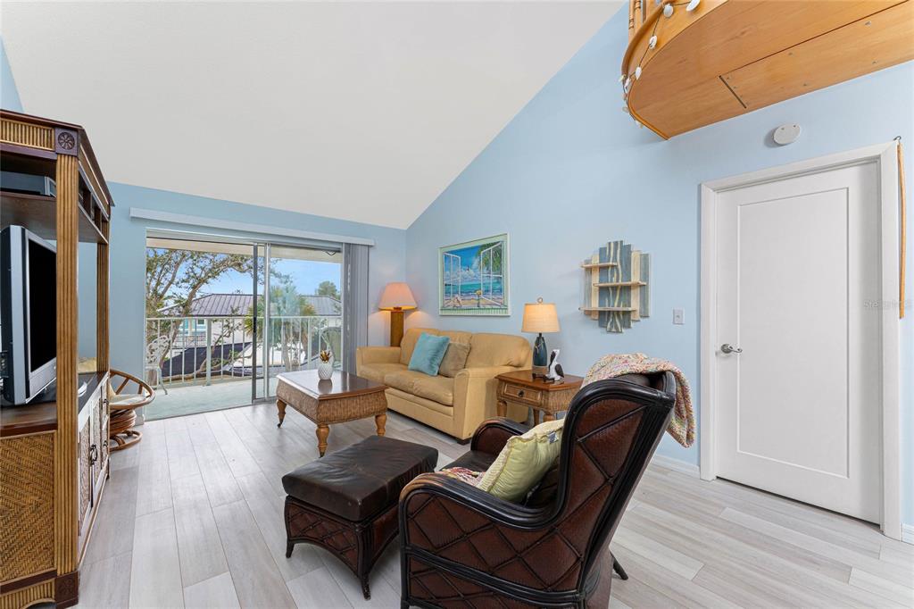 5031 North Beach Road, Unit 222 Englewood, FL 34223 - Photo 14 of 64 a living room with furniture a large window and a flat screen tv