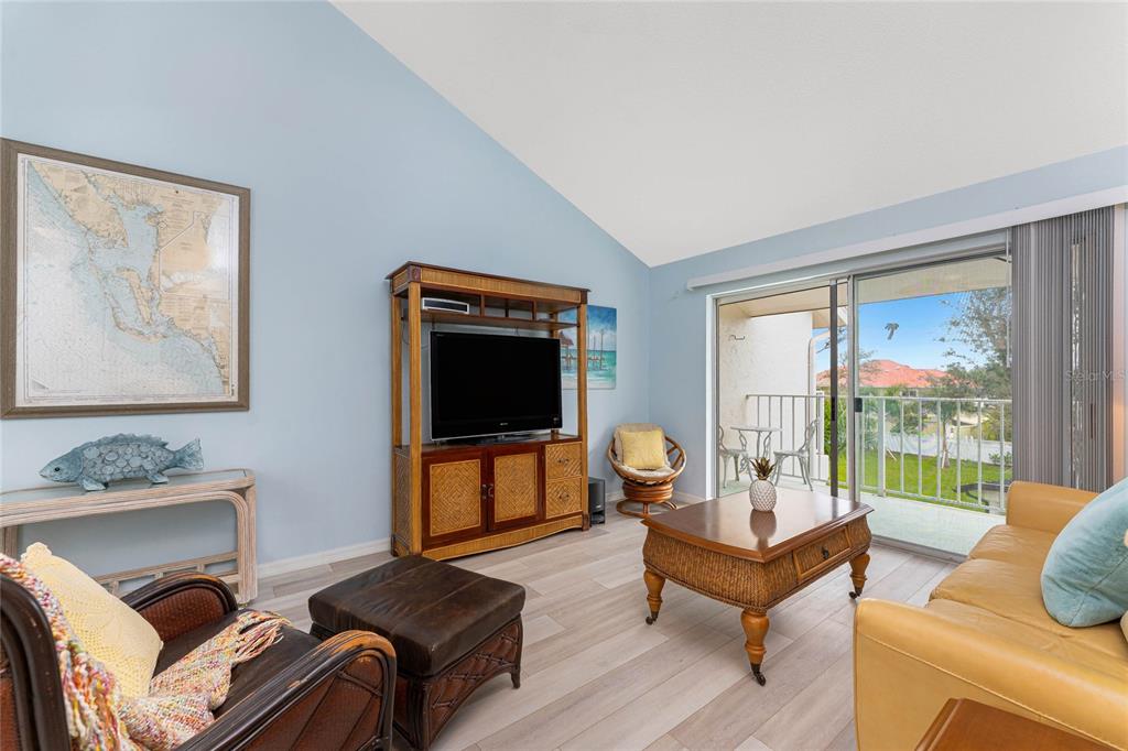 5031 North Beach Road, Unit 222 Englewood, FL 34223 - Photo 15 of 64 a living room with furniture and a flat screen tv