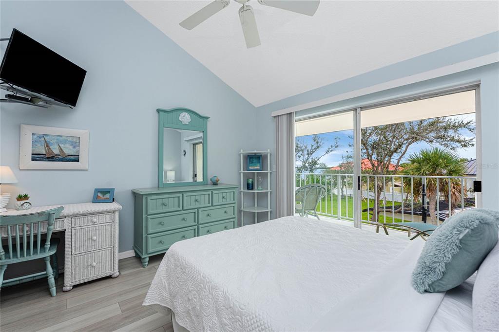 5031 North Beach Road, Unit 222 Englewood, FL 34223 - Photo 18 of 64 a bedroom with a bed a large window and flat screen tv