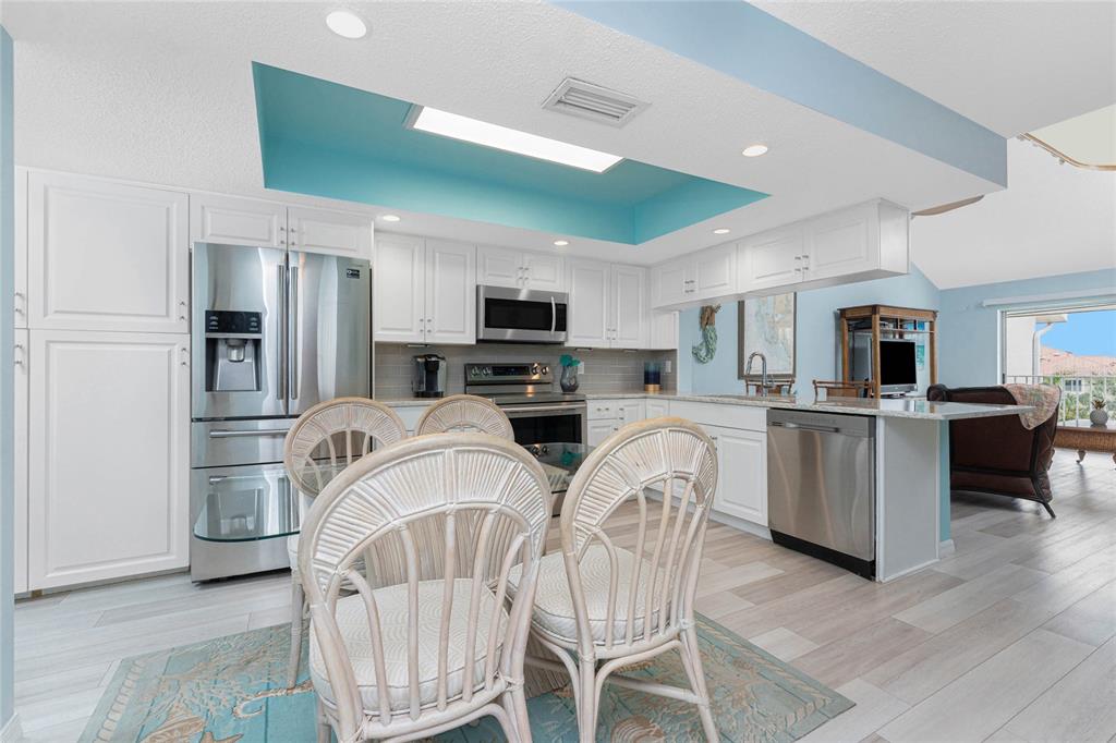 5031 North Beach Road, Unit 222 Englewood, FL 34223 - Photo 5 of 64 a open kitchen with white cabinets and stainless steel appliances