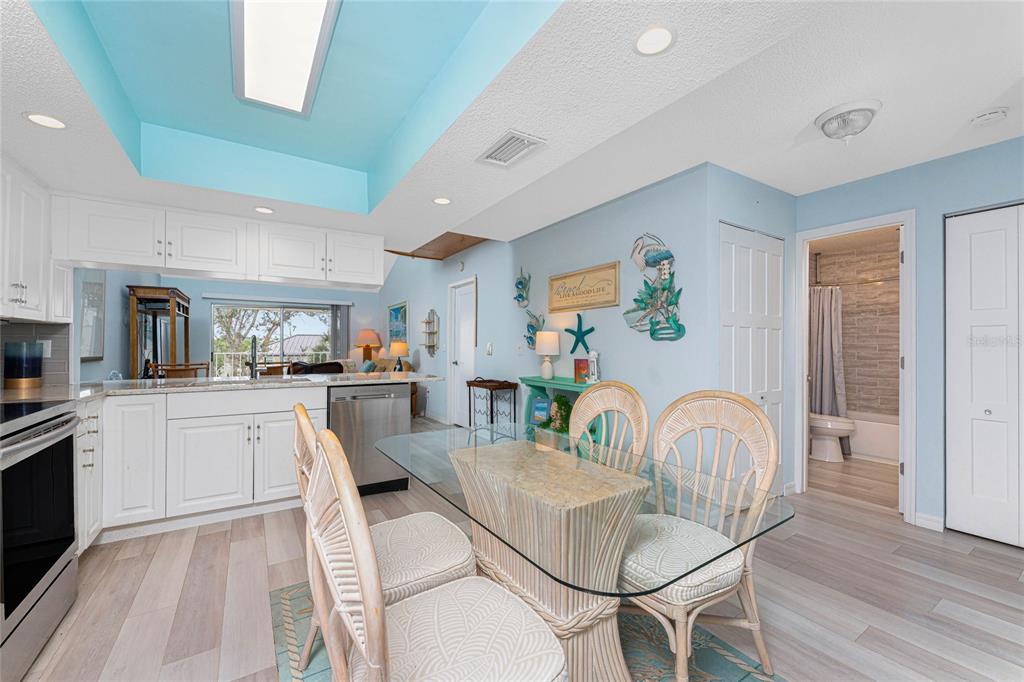 5031 North Beach Road, Unit 222 Englewood, FL 34223 - Photo 7 of 64 a kitchen with stainless steel appliances granite countertop a stove a sink a dining table and chairs