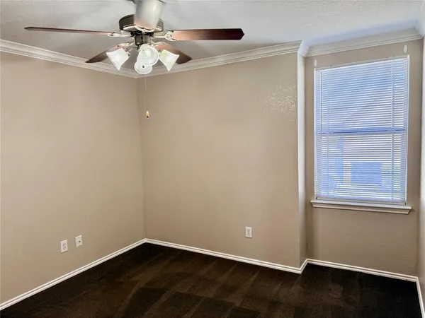 an empty room with a window and a ceiling fan