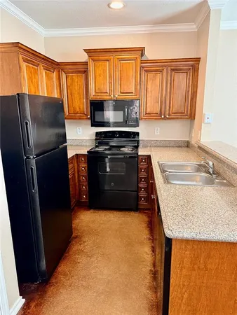 a kitchen with granite countertop a refrigerator a stove a sink and dishwasher