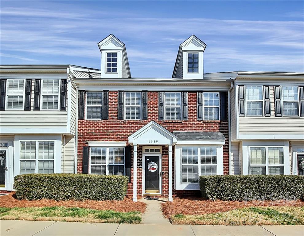 front view of brick house with a yard