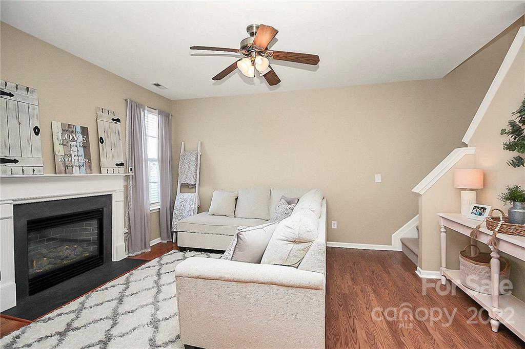 7589 Bluff Point Lane Denver, NC 28037 - Photo 11 of 36 a living room with furniture a fireplace and a ceiling fan