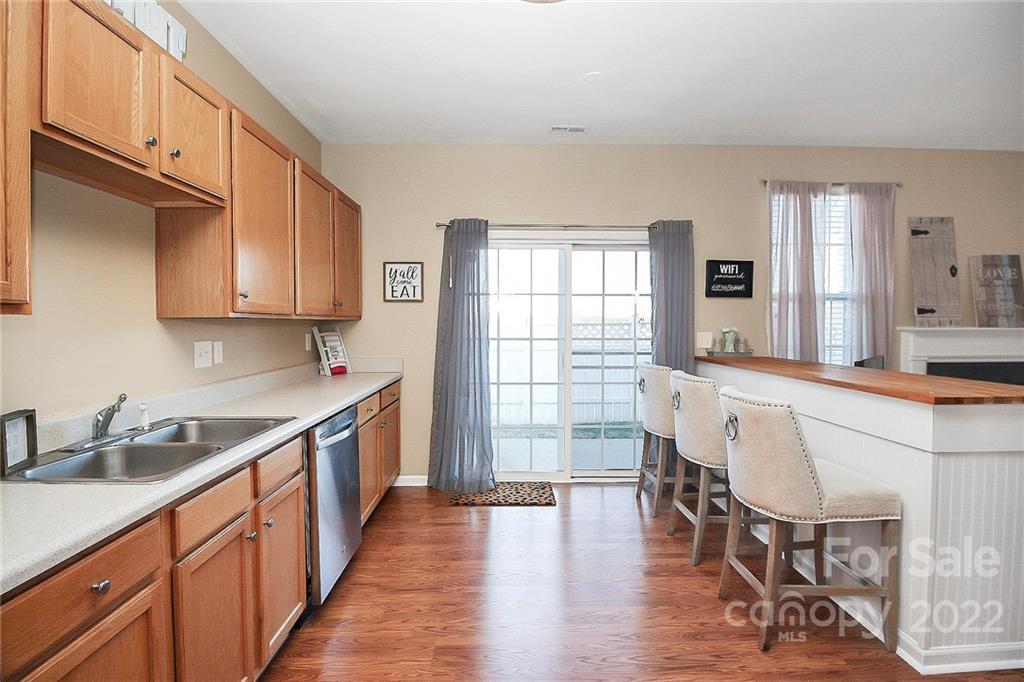 7589 Bluff Point Lane Denver, NC 28037 - Photo 14 of 36 a large kitchen with white cabinets and wooden floor