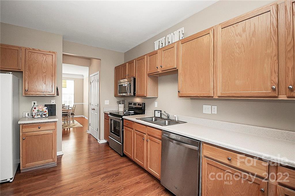 7589 Bluff Point Lane Denver, NC 28037 - Photo 17 of 36 a kitchen with stainless steel appliances granite countertop a refrigerator a sink dishwasher and white cabinets with wooden floor