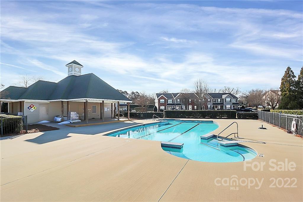 7589 Bluff Point Lane Denver, NC 28037 - Photo 36 of 36 a view of a swimming pool with lawn chairs under an umbrella