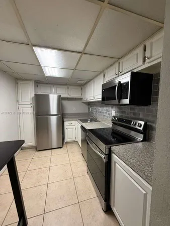 a kitchen with stainless steel appliances granite countertop a stove a refrigerator and a microwave