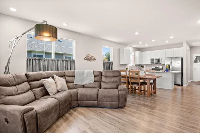 a living room with furniture and a view of kitchen