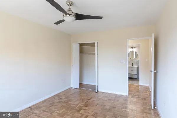 an empty room with a ceiling fan and bathroom
