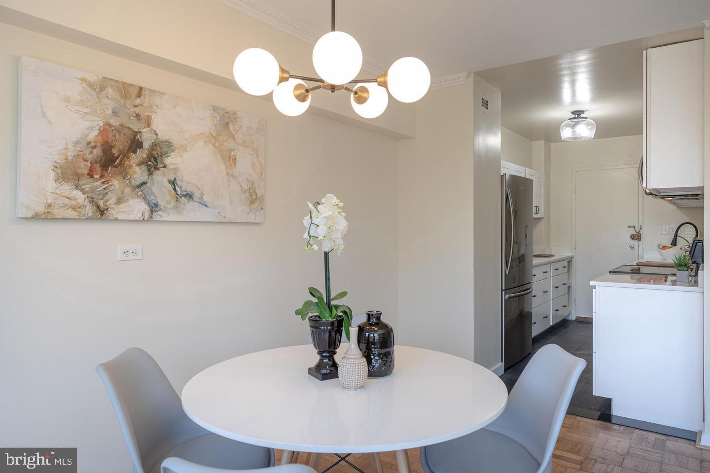 4600 Connecticut Avenue Northwest, Unit 601 Washington, DC 20008 - Photo 7 of 21 a dining room with wooden floor a chandelier a wooden table and chairs