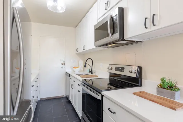 a kitchen with stainless steel appliances a sink stove and microwave