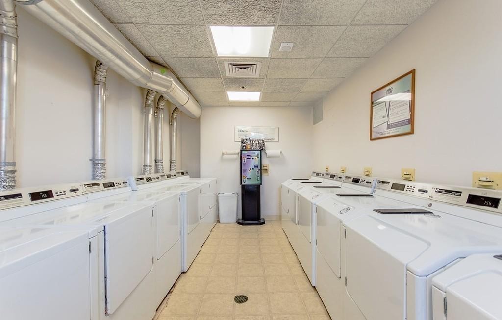 534 Beacon Street, Unit 502 Boston, MA 02215 - Photo 15 of 18 a large white kitchen with a stove a sink a washer dryer and white cabinets