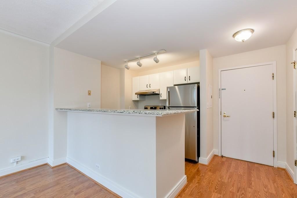 534 Beacon Street, Unit 502 Boston, MA 02215 - Photo 4 of 18 a view of kitchen with refrigerator cabinets and wooden floor