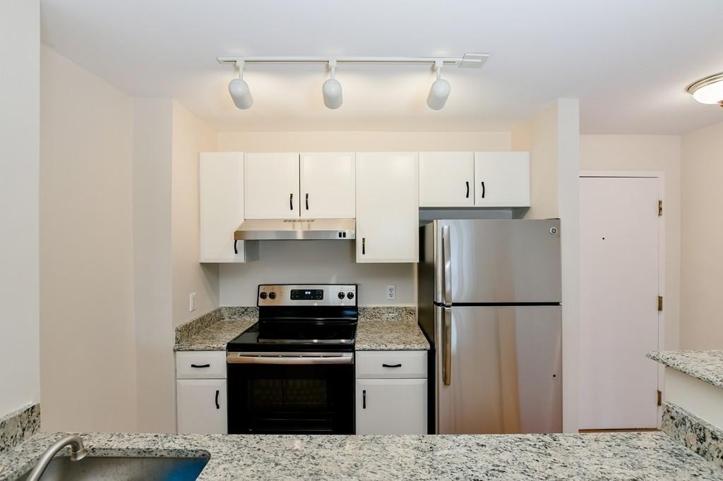 534 Beacon Street, Unit 502 Boston, MA 02215 - Photo 5 of 18 a kitchen with a refrigerator stove and white cabinets