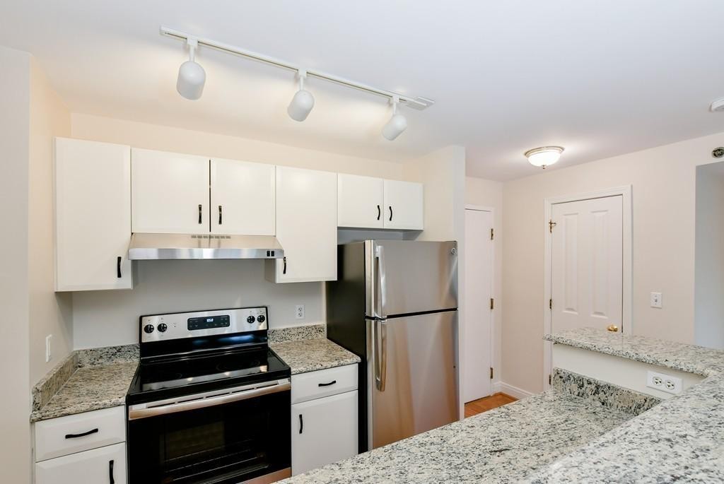 534 Beacon Street, Unit 502 Boston, MA 02215 - Photo 6 of 18 a kitchen with a refrigerator stove and white cabinets