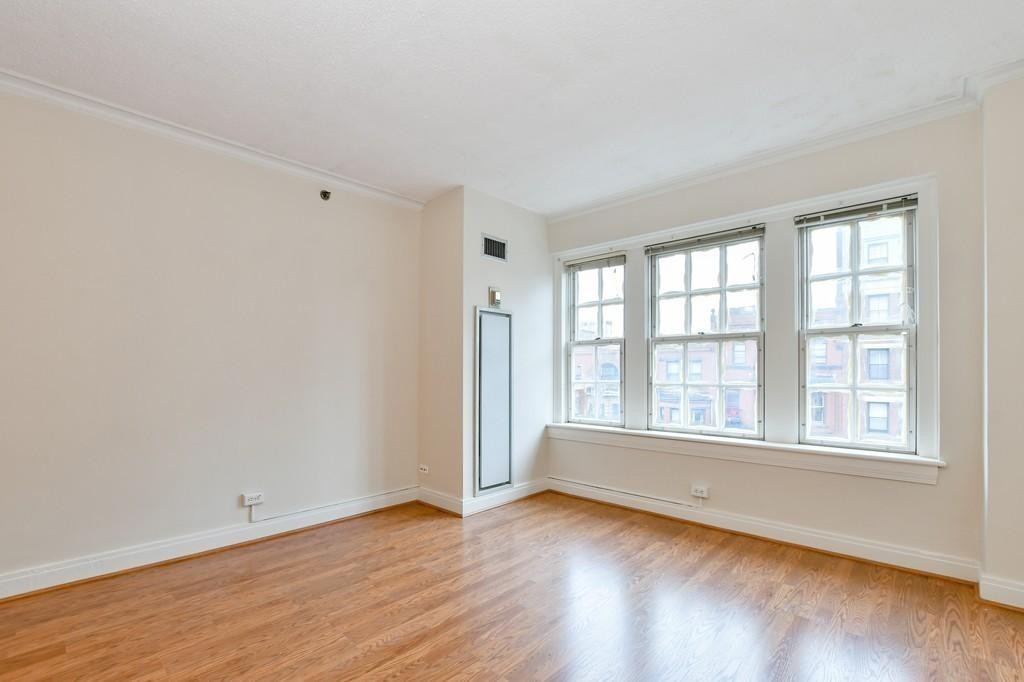 534 Beacon Street, Unit 502 Boston, MA 02215 - Photo 8 of 18 an empty room with wooden floor and windows