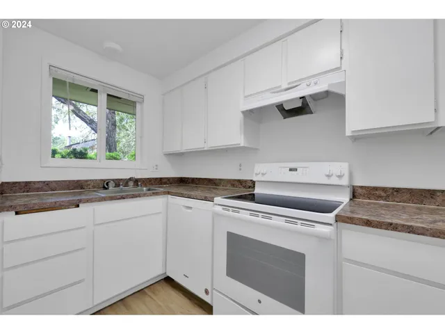 a kitchen with appliances cabinets and a window