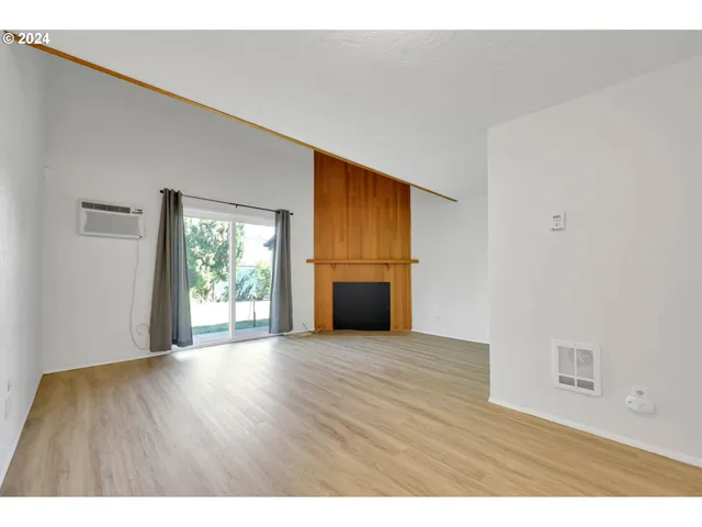 a view of a room with wooden floors and windows