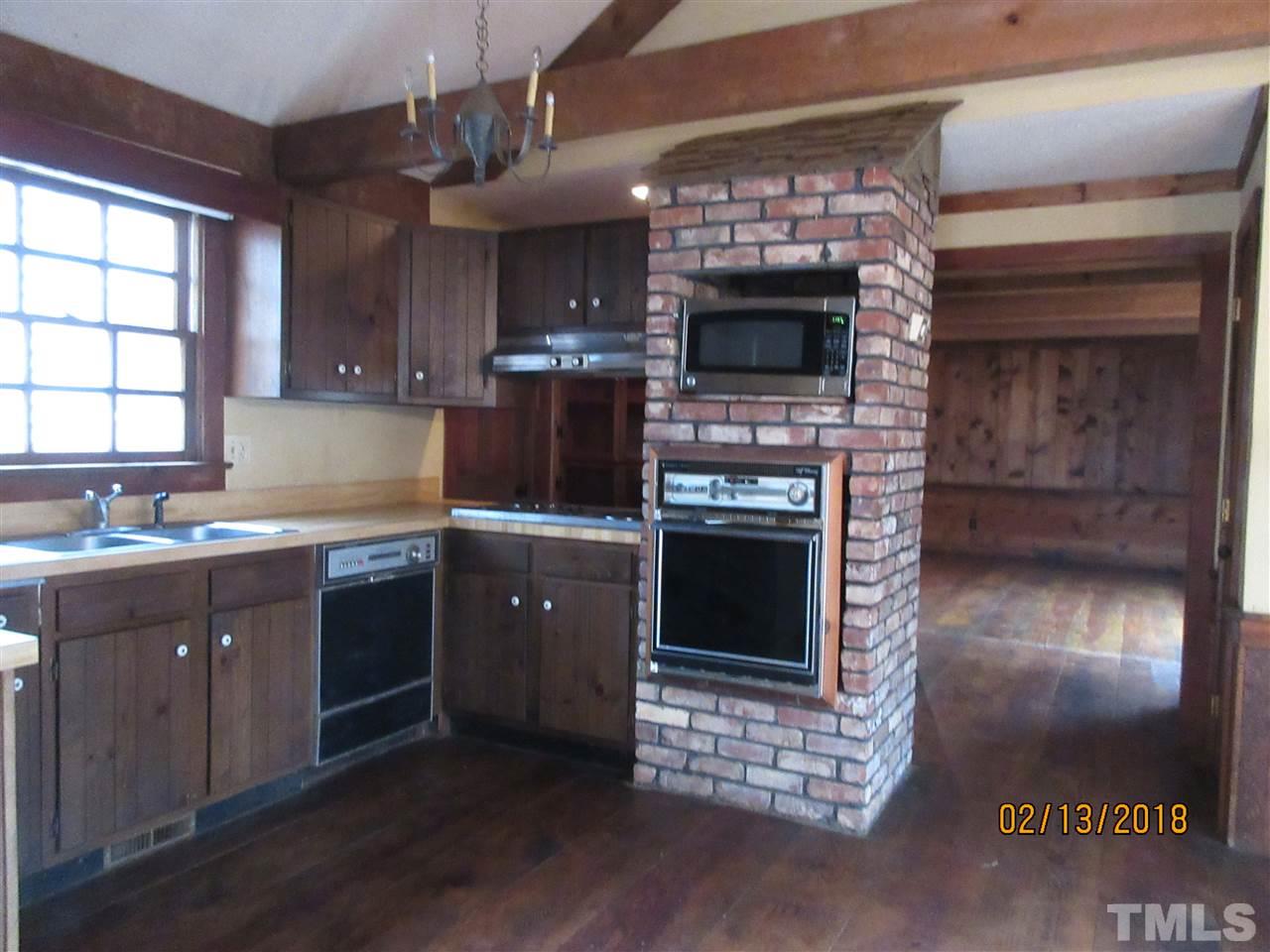 BRICK wall for oven and sturdy wide plank hardwoods are timeless.